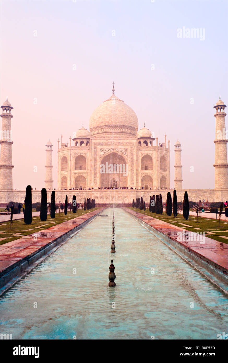 INDIA AGRA monumento del Taj Mahal si vede attraverso la nebbia di mattina e la fontana di spruzzare alla sunrise come turisti indiano tour UNESCO Foto Stock