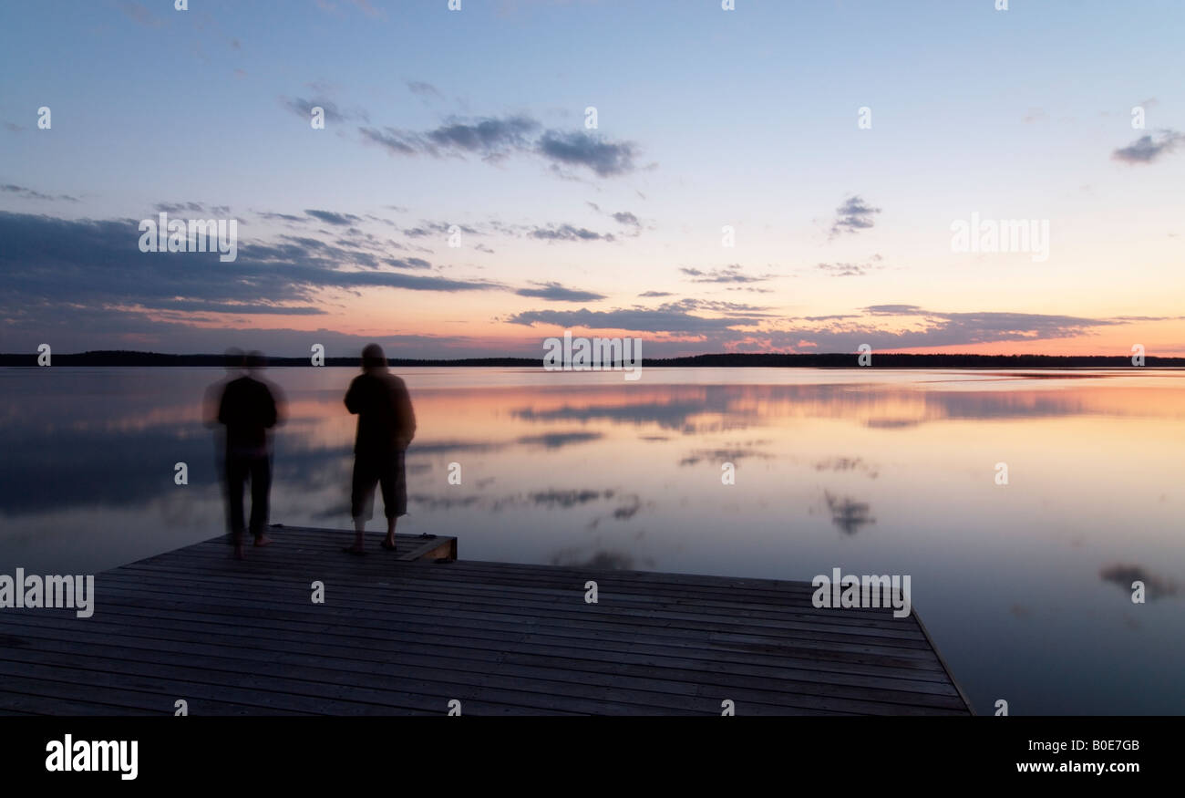 Due persone dal lago calmo Päijänne sul tranquillo inizio notte estiva, Asikkala, Finlandia Foto Stock