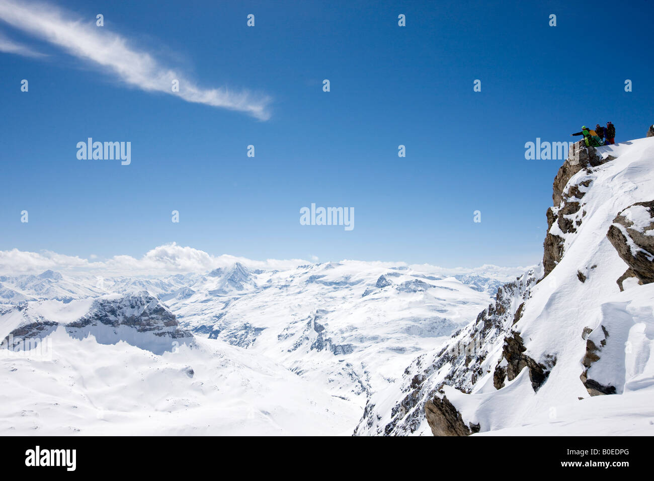 Gli appassionati di snowboard che guarda oltre le montagne nevose Foto Stock