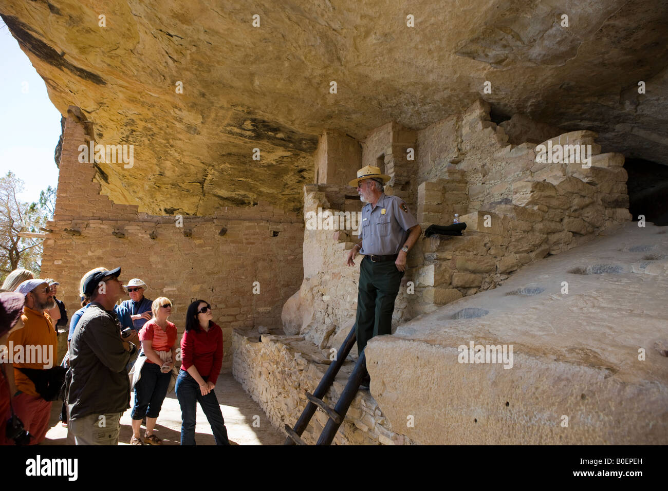 Un US National Parks ranger parla a un gruppo di visitatori nel balcone rovine della casa il Parco Nazionale di Mesa Verde nei pressi di Cortez Colorado Foto Stock