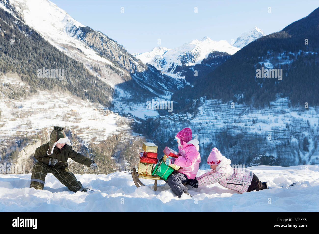 I bambini a giocare nella neve con presenta Foto Stock