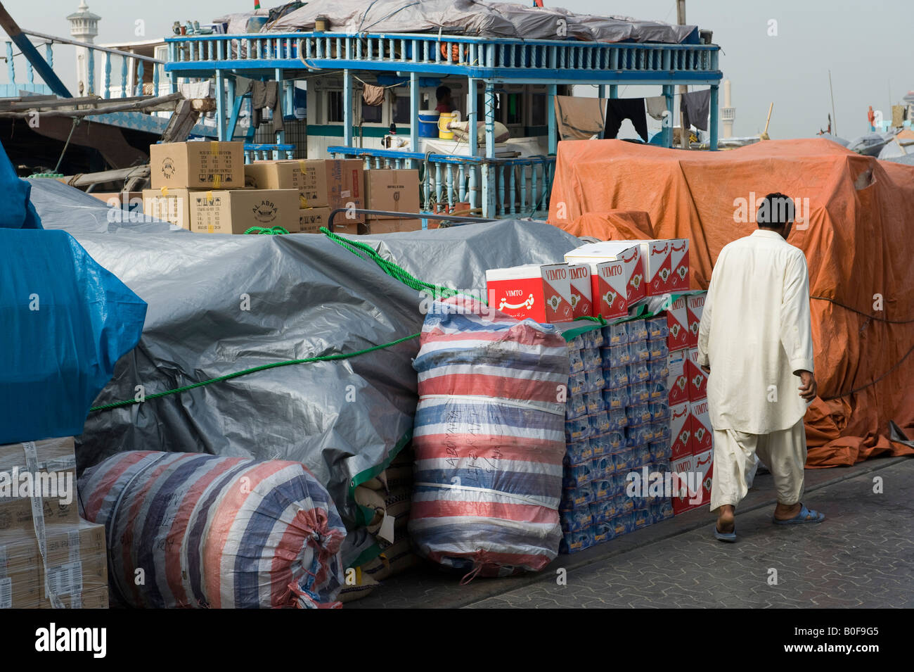 Dubai, Emirati arabi uniti (EAU). Cargo impilati lungo la banchina sul Dubai Creek nella città vecchia, in attesa dei mezzi di trasporto Foto Stock