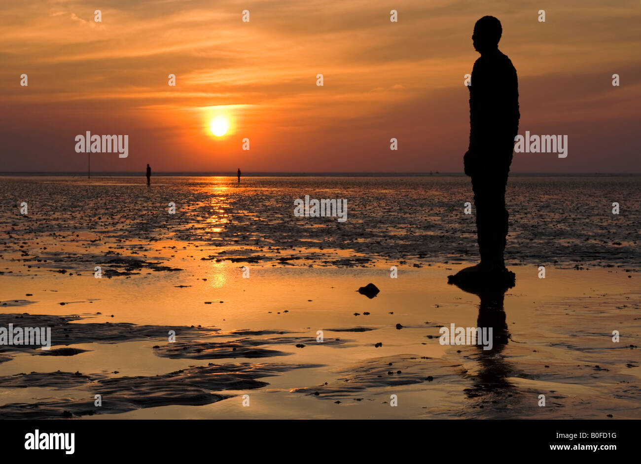 Antony Gormley è un altro posto statue al tramonto sulla spiaggia Crosby, Crosby, Merseyside England, Regno Unito Foto Stock