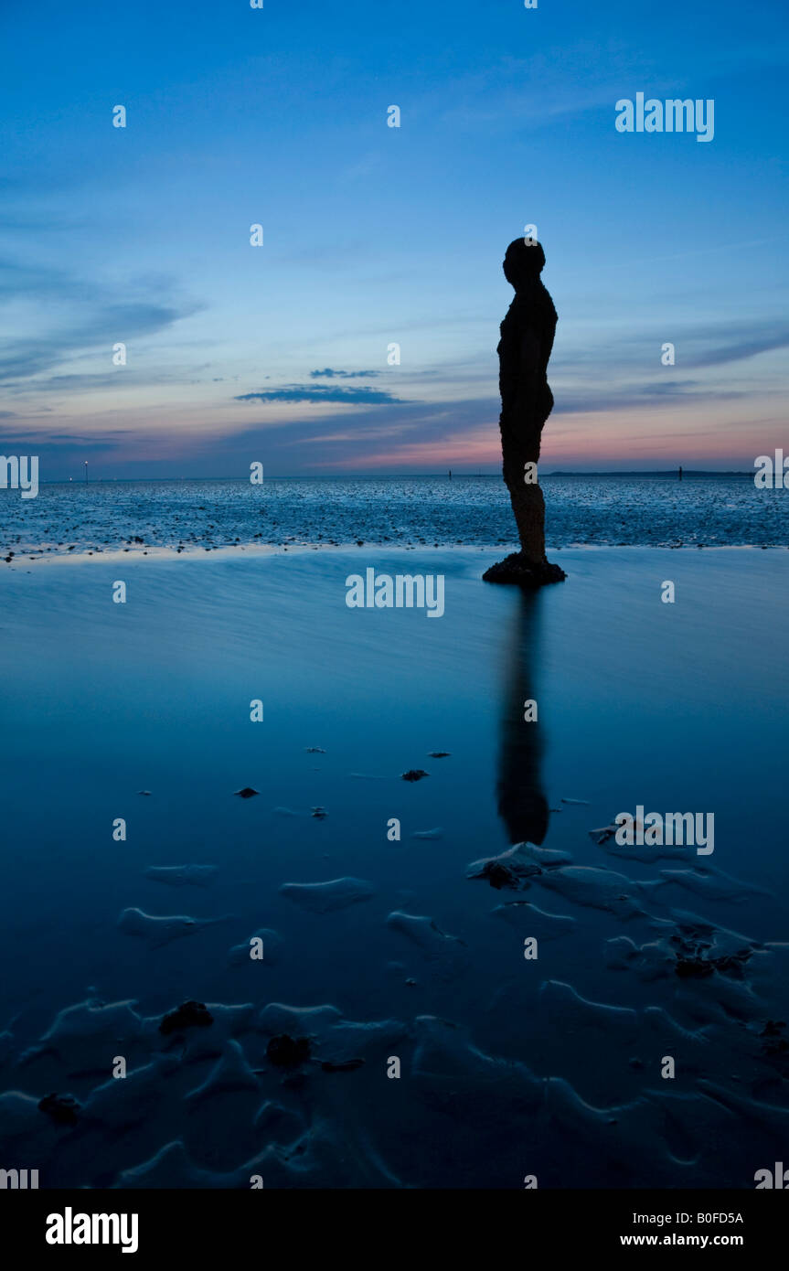 Antony Gormley è un altro posto statue al crepuscolo su Crosby Beach, Crosby, Merseyside England, Regno Unito Foto Stock