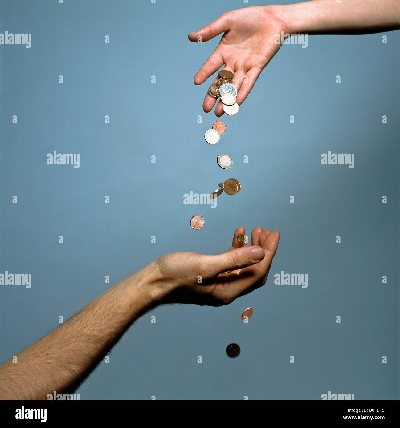 Le mani la caduta delle monete in euro Foto Stock