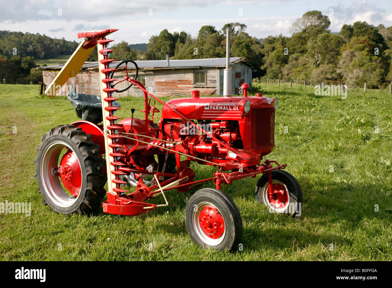 Antique 1952 International Farmall Cub trattore con una falciatrice Foto Stock