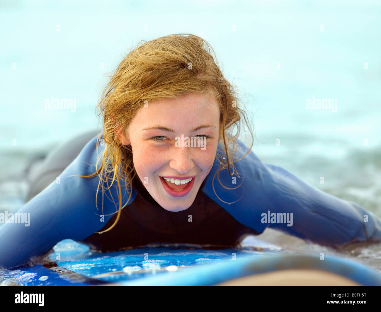 Femmina su tavola da surf tenendo piccola onda Foto Stock