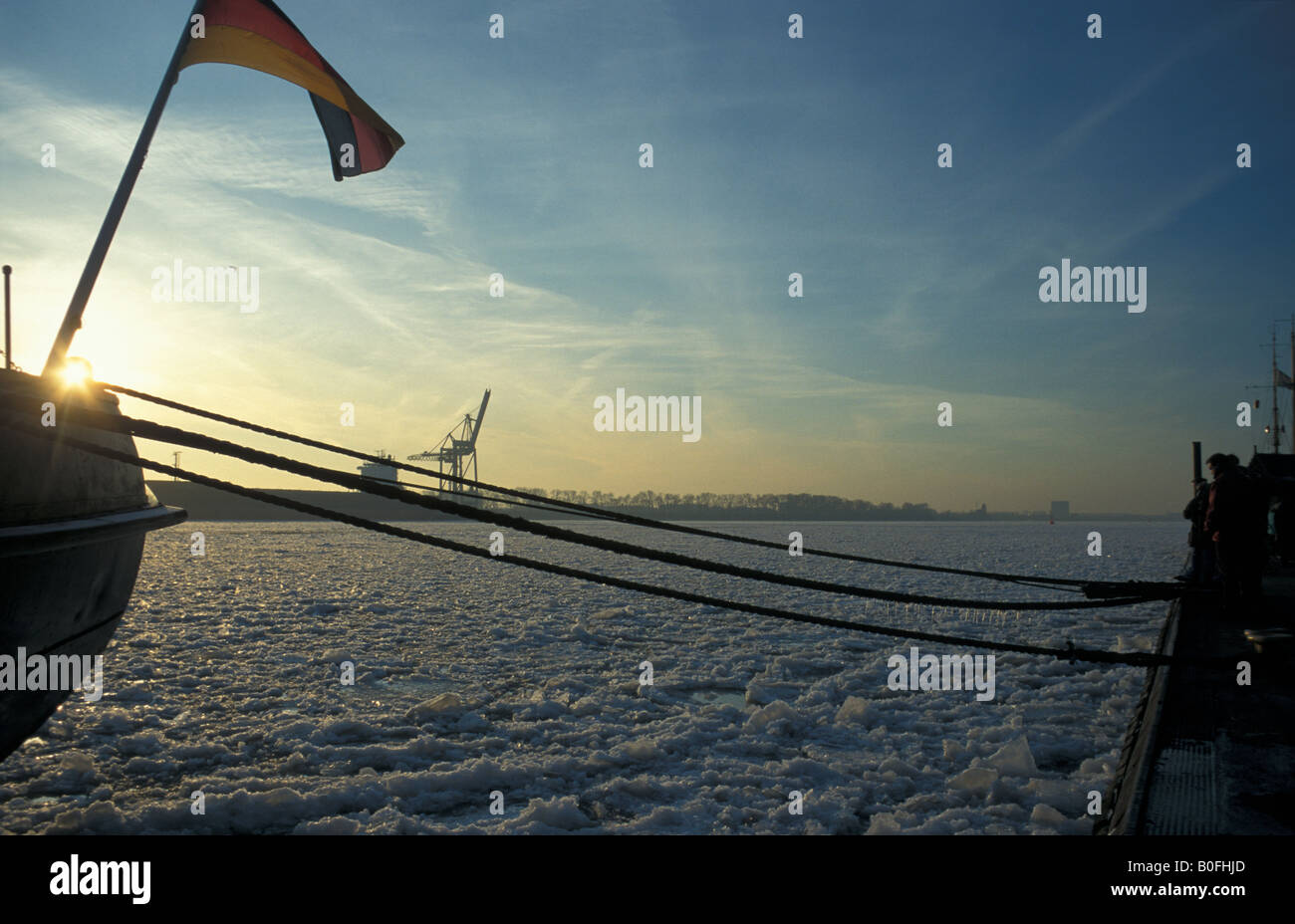Bandiera tedesca sulla storica icebreaker 'Stettin' presso il molo 'Neumuehlen', ghiaccio galleggiante sul fiume Elba a Amburgo, Germania Foto Stock
