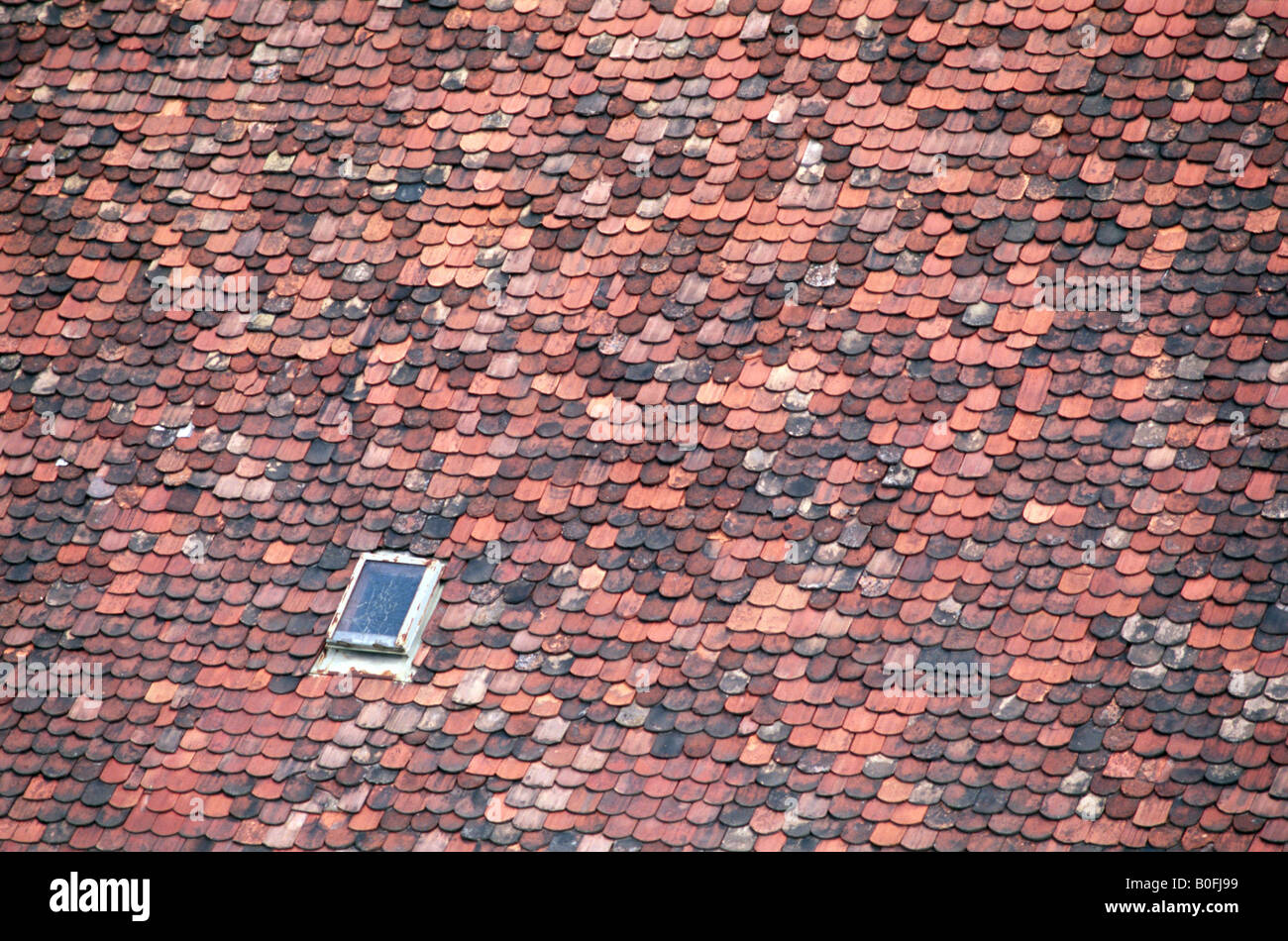 Vecchio rosso tegole sul tetto con finestra Foto Stock