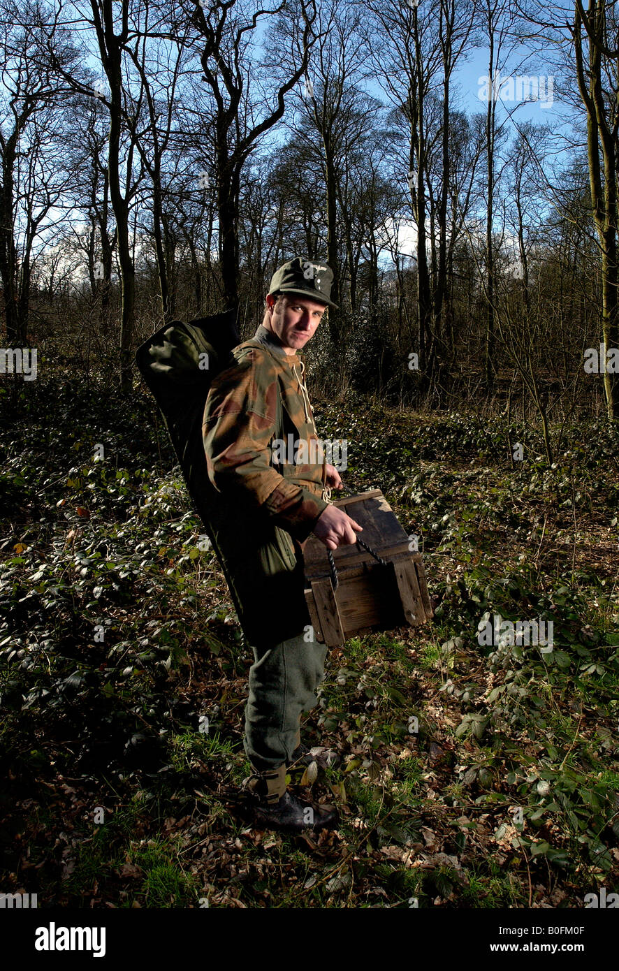 Il tedesco della Seconda Guerra Mondiale la Seconda Guerra Mondiale SS rievocazione soldato in camo camouflage con munizioni scatola di munizioni Foto Stock