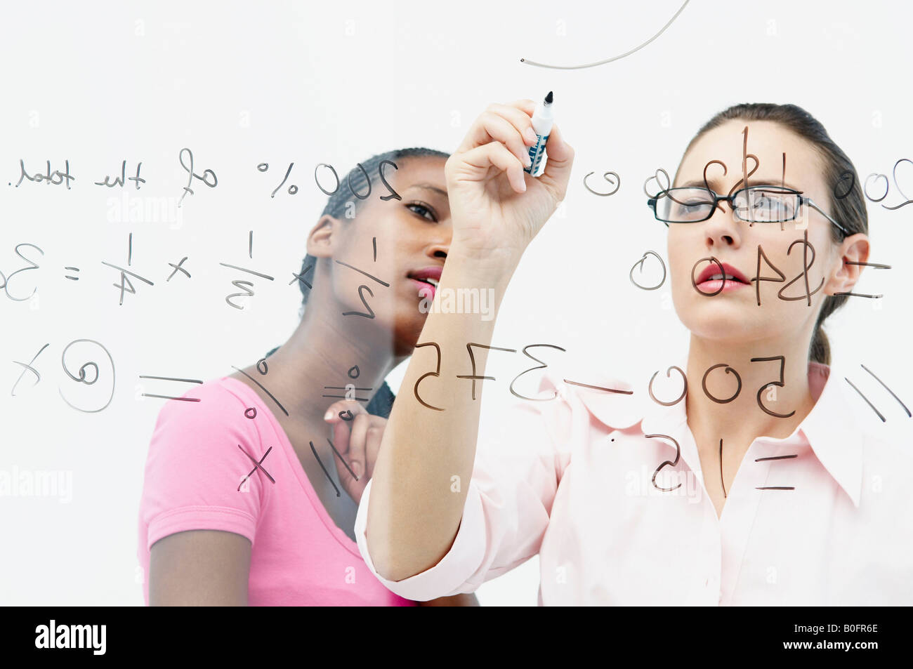 Due donne scrivere sul pannello di vetro Foto Stock