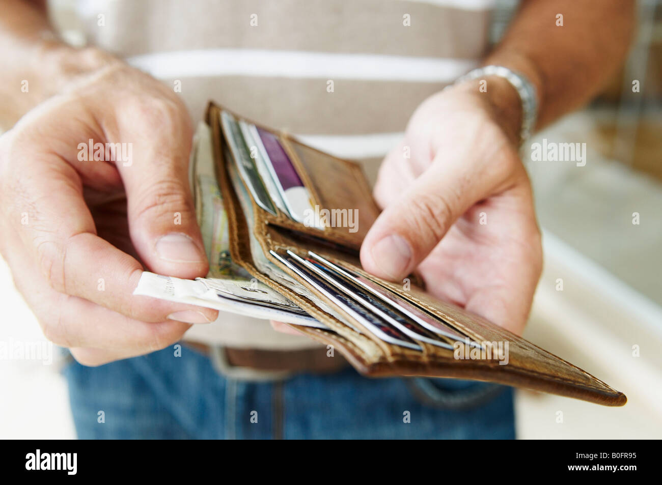L'uomo elimina contanti dal portafoglio Foto Stock