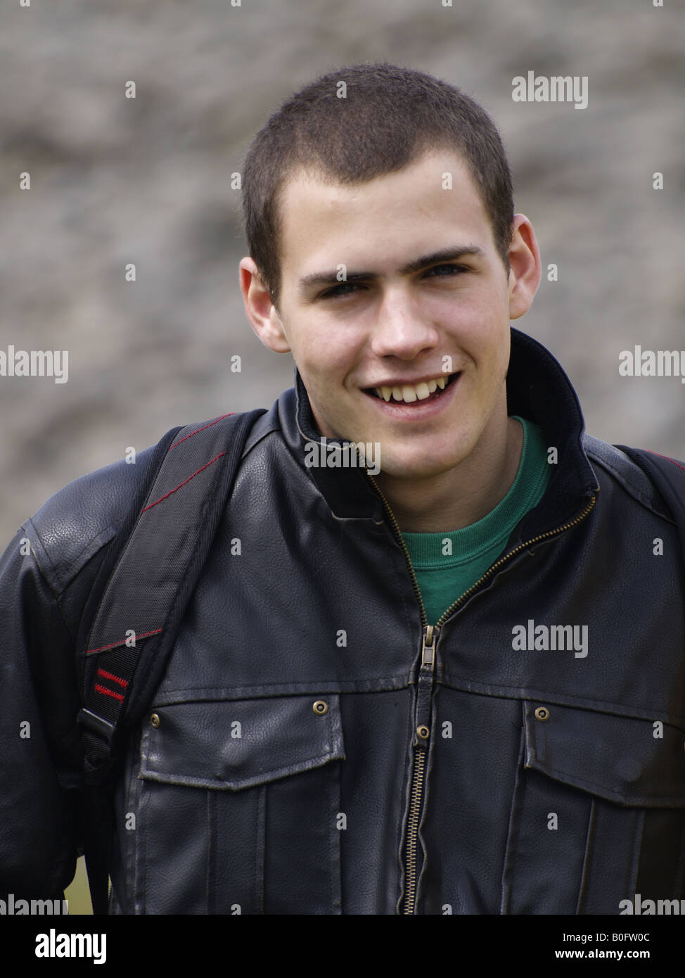 Felice grinning diciottenne ragazzo adolescente in una giacca di pelle Foto Stock
