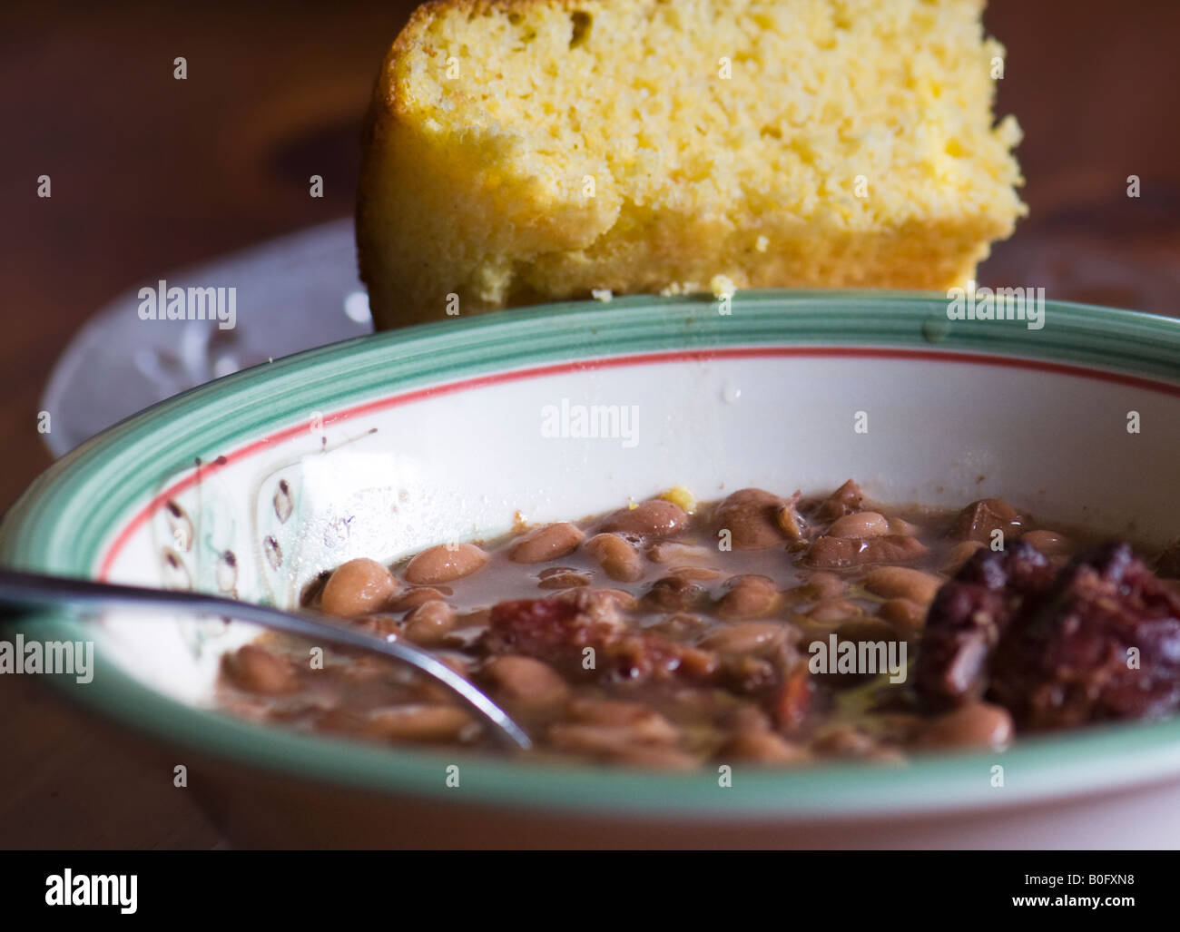 Un recipiente di cottura i fagioli borlotti e il garretto. Un pezzo di cornbread poggia contro la coppa. Primo piano. Cucina meridionale, la cucina del sud. Oklahoma, Stati Uniti d'America. Foto Stock