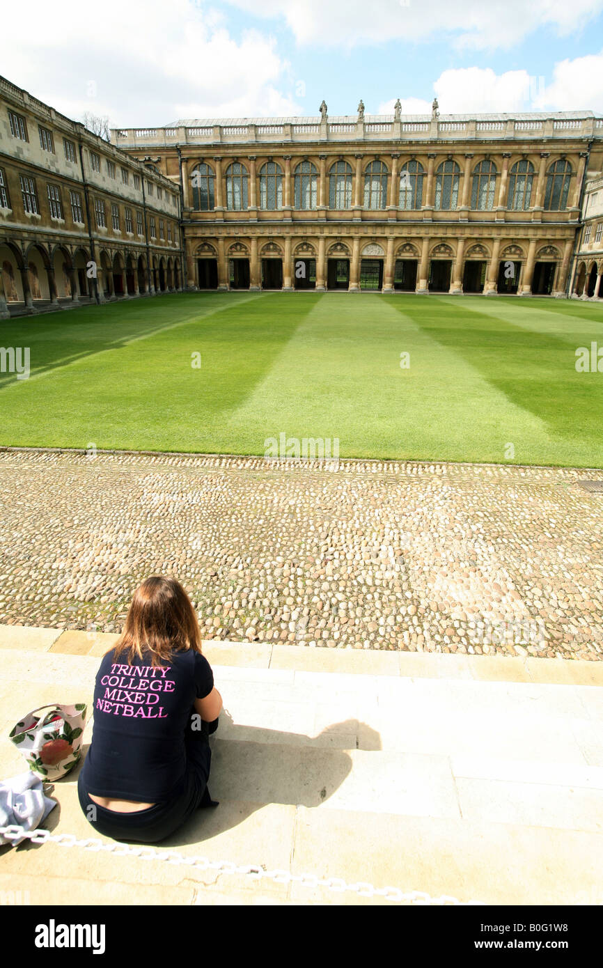 Uno studente si siede in Nevile la corte rivolta verso la Wren library del Trinity College di Cambridge Inghilterra England Foto Stock