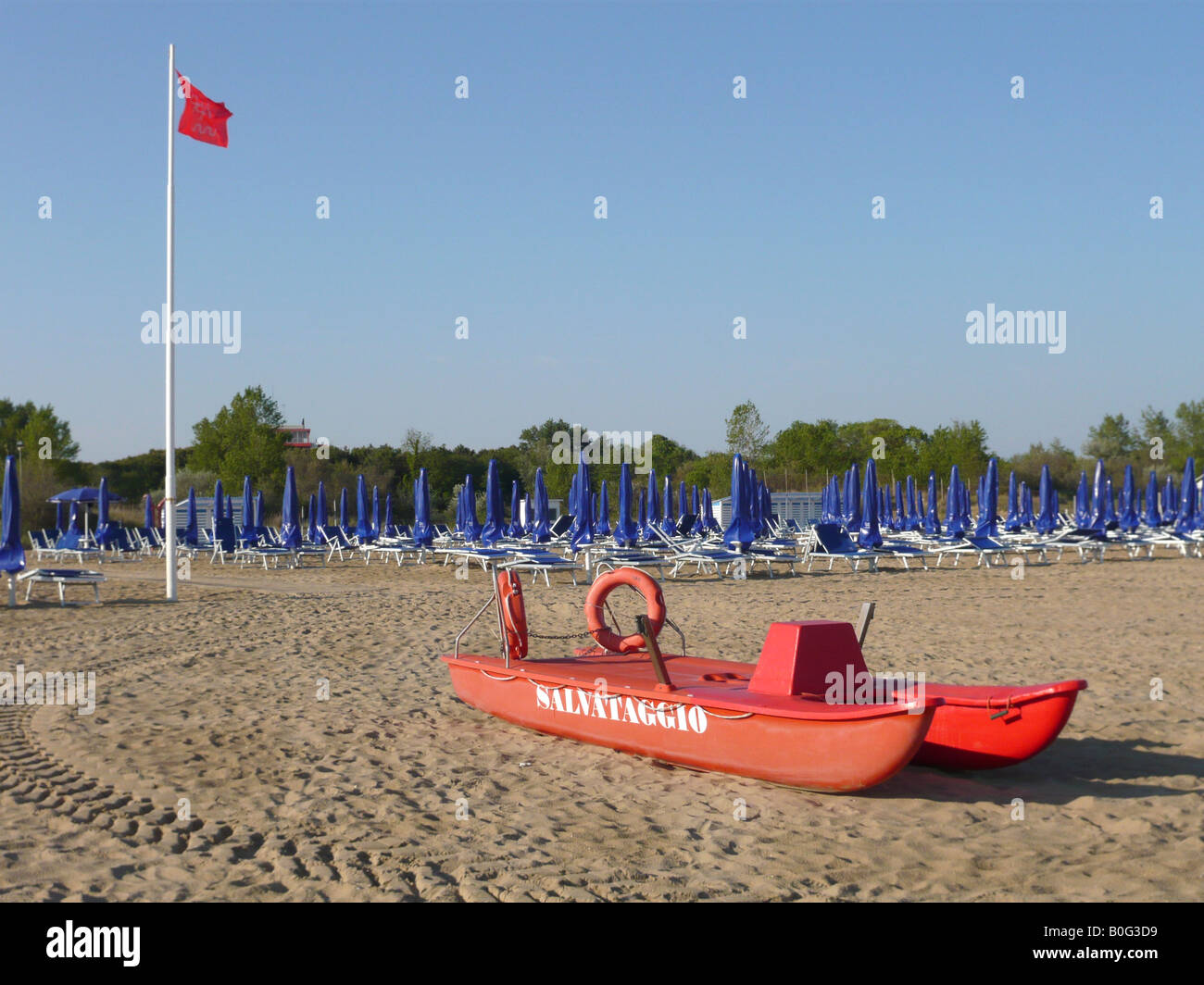 Spiaggia di Bibione Pineda con bandiera rossa e la barca di salvataggio - appena fatto pronte per lo start della stagione. Foto Stock