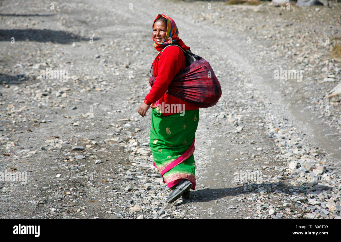 Tradizionalmente condita gurung lady camminando lungo il percorso nell'Annapurna nepal Foto Stock