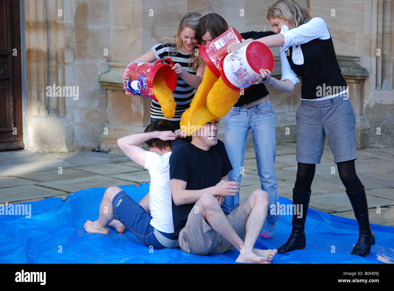 Due studenti che vengono coperti con crema pasticcera. Foto Stock