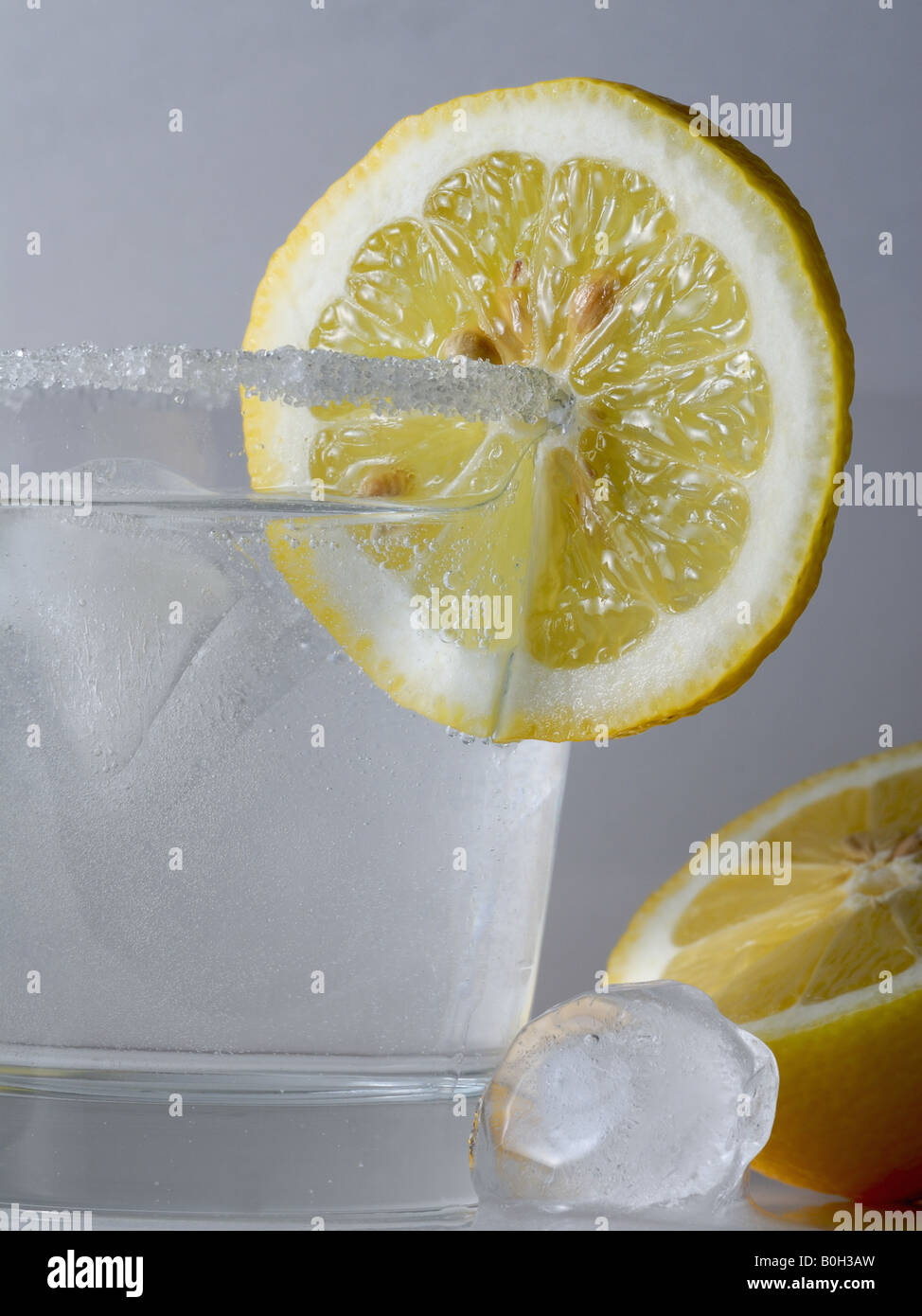 Un cocktail glas con acqua, succo di limone e ghiaccio Foto Stock