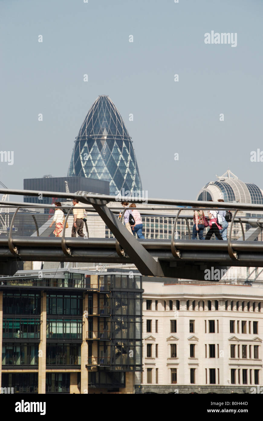 Le persone che attraversano il Millennium Bridge con la City di Londra edifici in background Londra Regno Unito 2008 Foto Stock