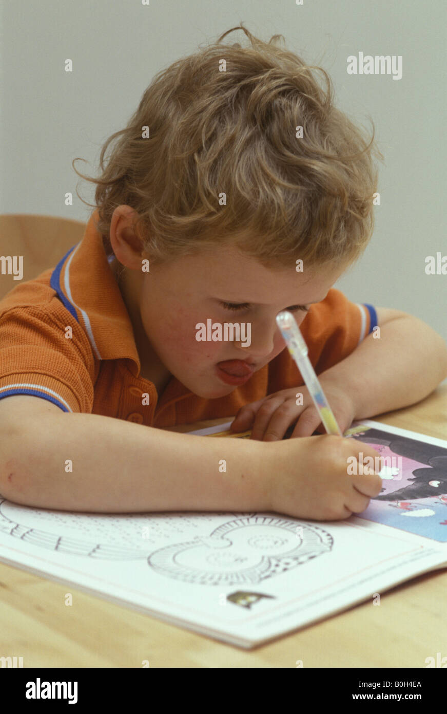 Ragazzo concentrare sul disegno le sue lettere Foto Stock
