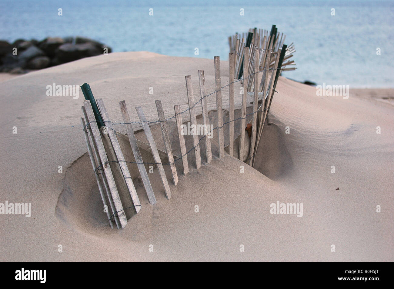 Un avvolgimento staccionata in legno nel pulire scolpita la sabbia della spiaggia di manhattan durante il tardo inverno che conduce all'oceano Foto Stock