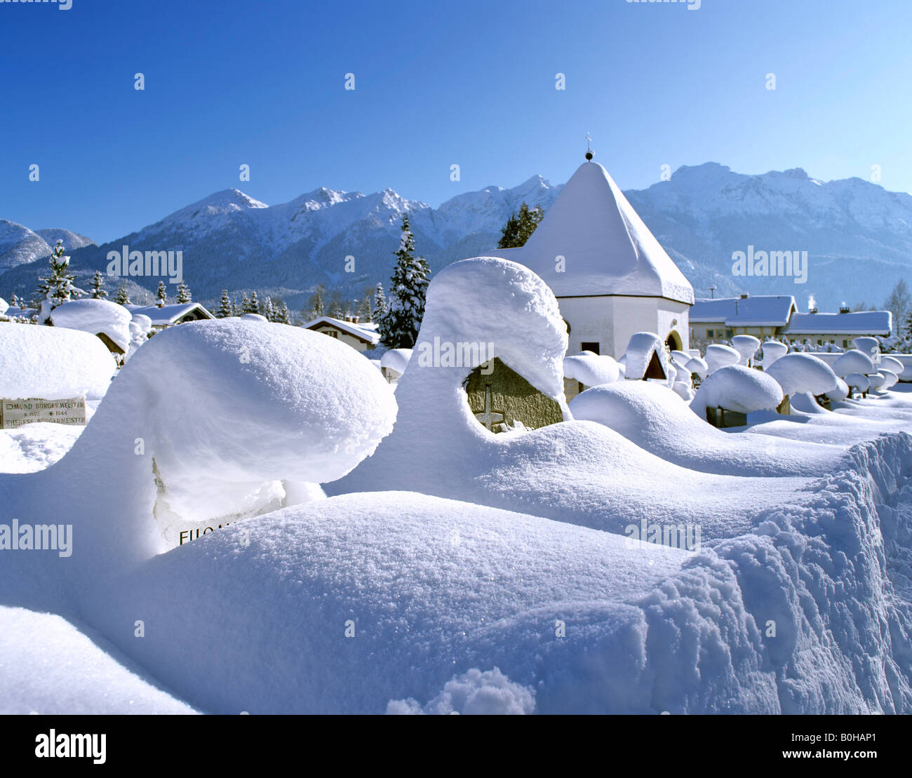 Coperte di neve lapidi. in inverno, il cimitero Mittenwald, Alta Baviera, Baviera, Germania Foto Stock