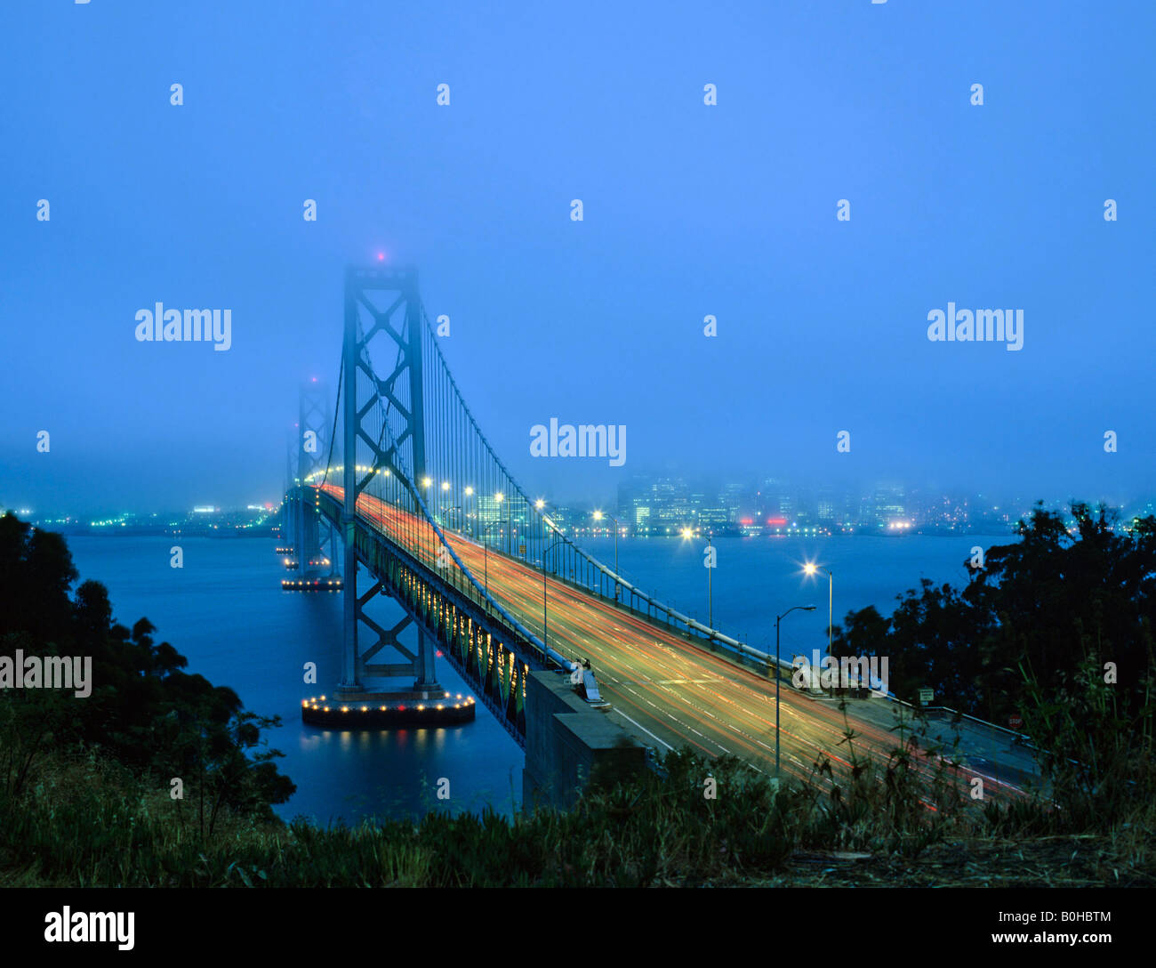 Il Bay Bridge, skyline al tramonto, San Francisco, California, Stati Uniti d'America Foto Stock
