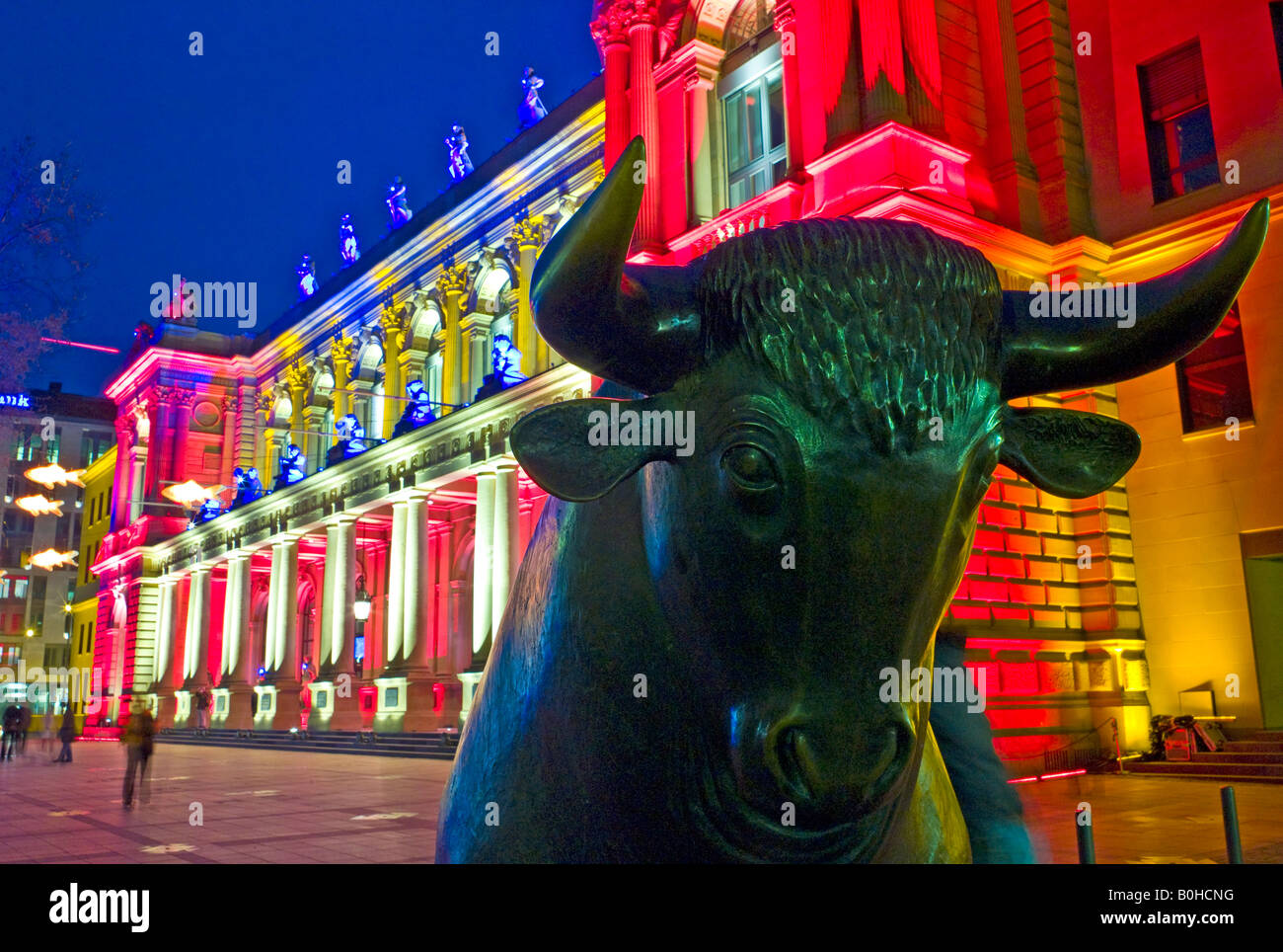 Il toro del toro e di portare di fronte alla luminosa Frankfurt Stock Exchange di notte illuminata da spot multicolore Foto Stock