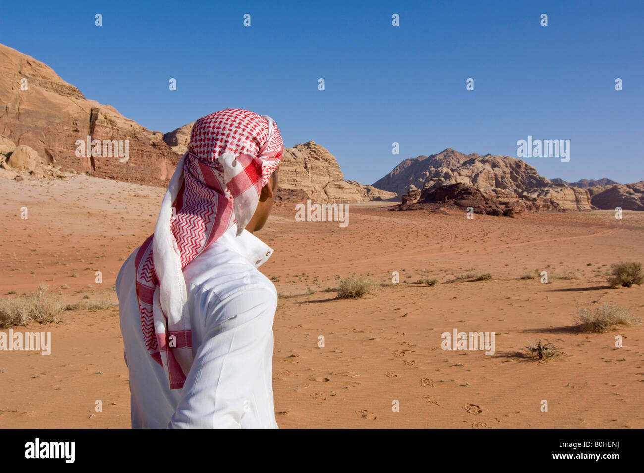 Bedouin guardando fuori nella distanza nel deserto, Wadi Rum, Giordania, Medio Oriente Foto Stock