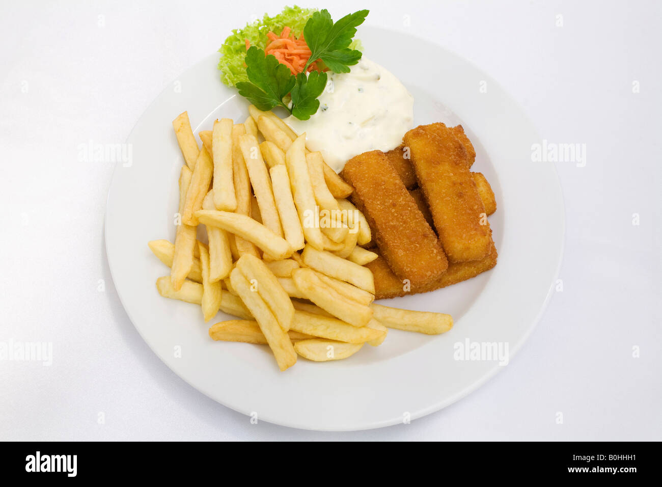Bastoncini di pesce, salsa tartara e patatine fritte servite su una piastra bianca Foto Stock