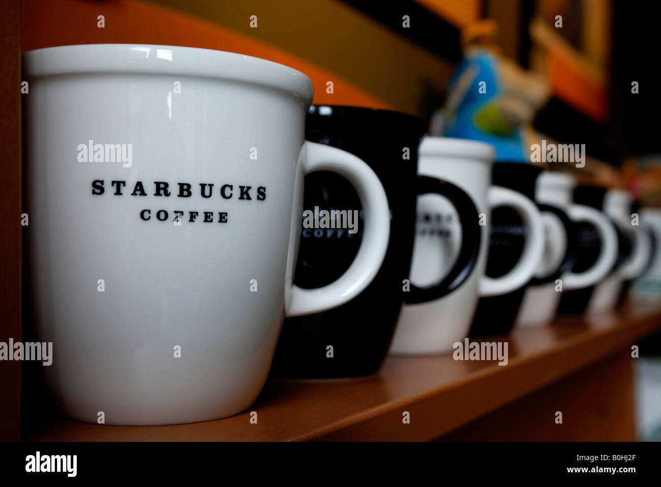 Bianco e nero caffè Starbucks mug in una fila su un ripiano, Stoccarda,  Baden-Wuerttenberg, Germania Foto stock - Alamy