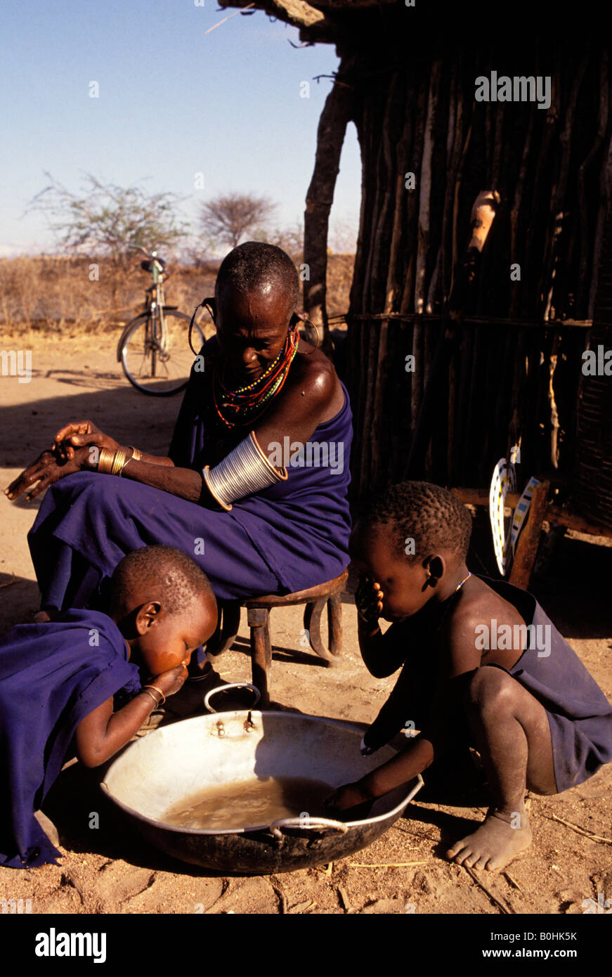 Bambini Masai il lavaggio al di fuori della loro casa in un villaggio vicino a Dodoma nel Boma regione , Rofati, Tanzania. Foto Stock