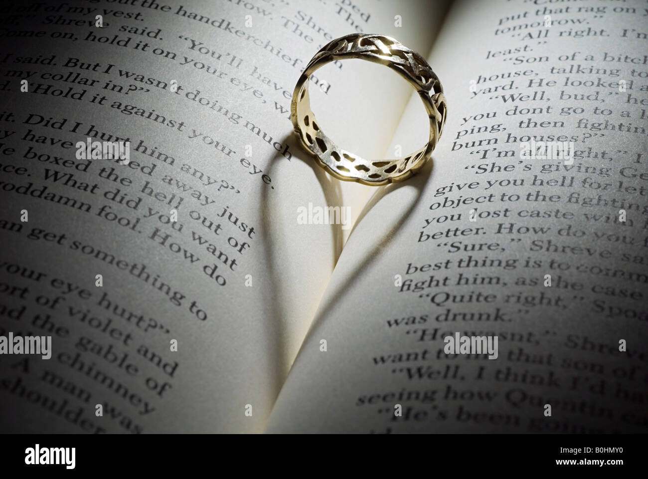 Anello nella piegatura di un libro aperto, shadow formando un cuore Foto Stock