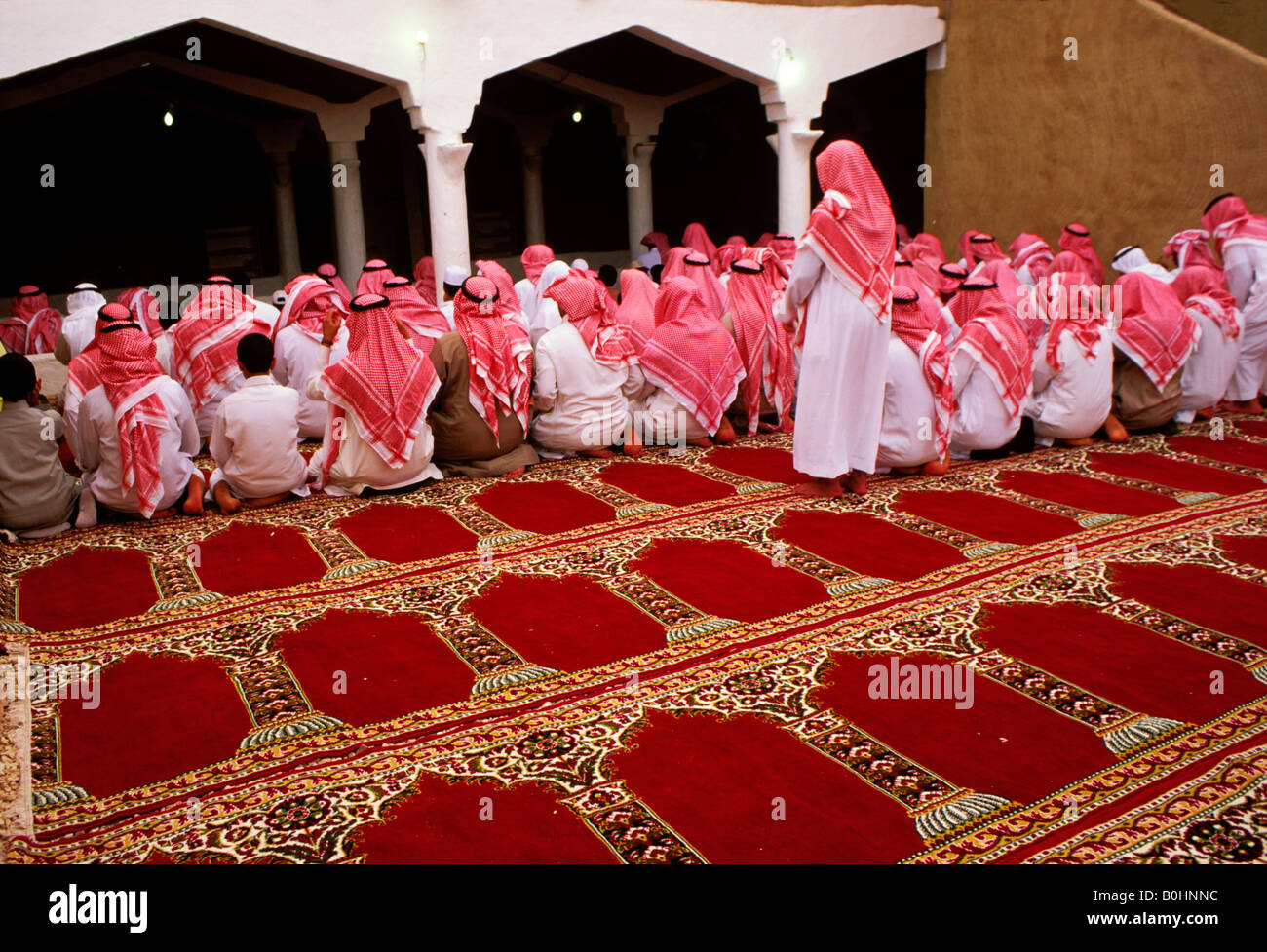 Gli uomini a una moschea per la preghiera di mezzogiorno, Arabia Saudita. Foto Stock