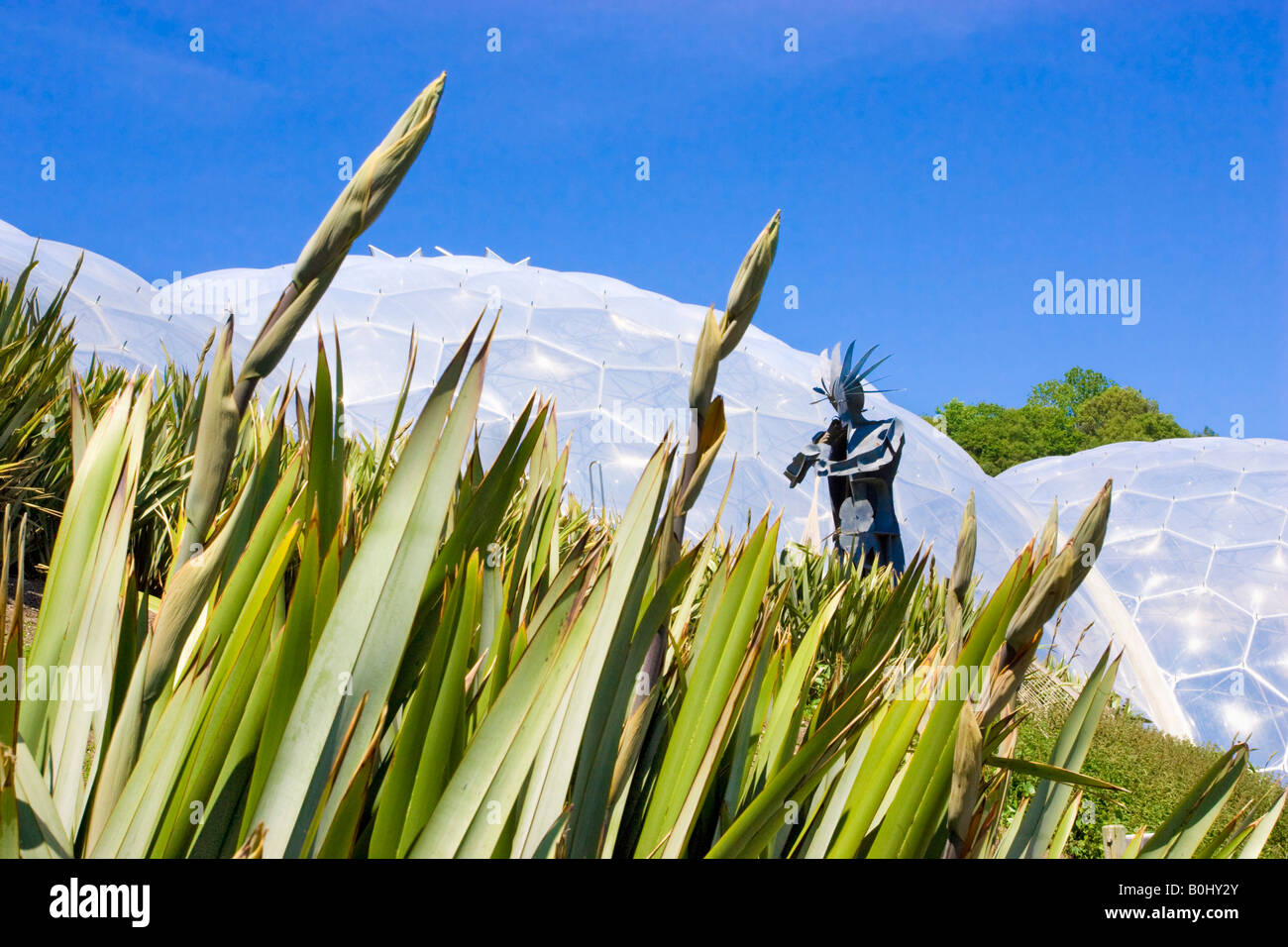 Metallo gigante Plowman scultura davanti la foresta pluviale (umido argomenti) Biome all'Eden Project, Cornwall. Foto Stock