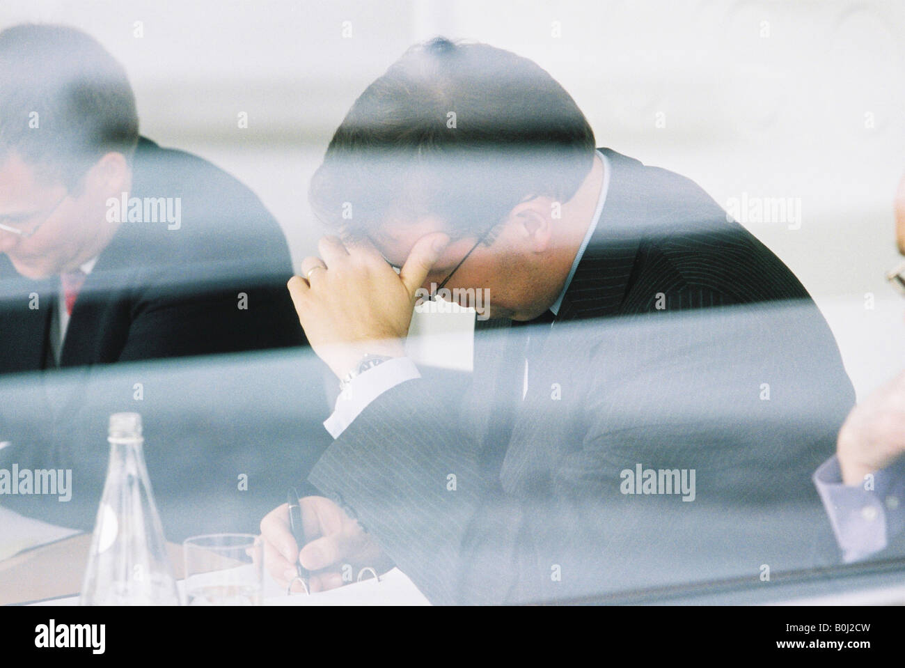 Comitato esecutivo meeting & acqua in bottiglia visto attraverso la finestra Foto Stock
