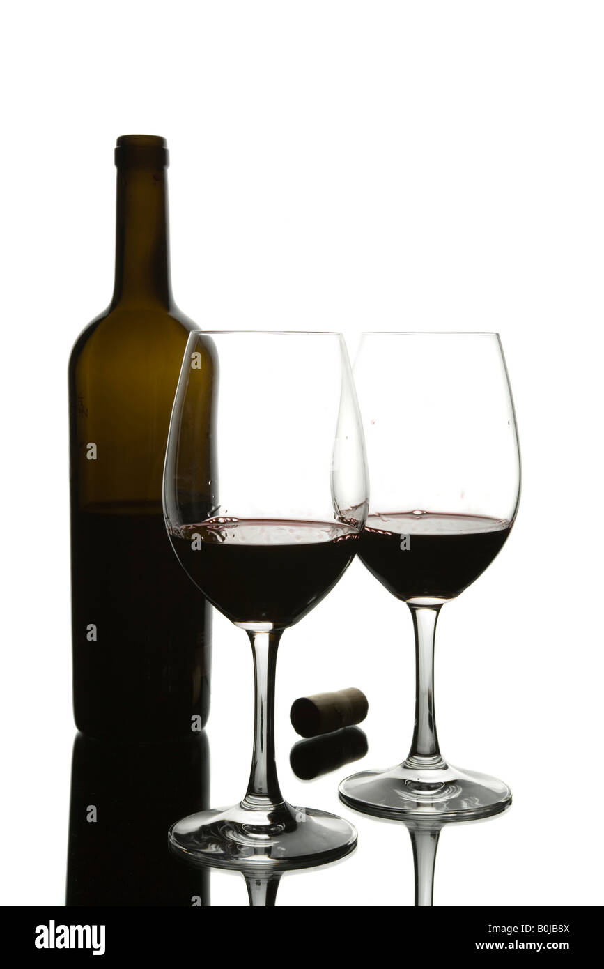 Due bicchieri di vino rosso e una bottiglia trasparente Foto Stock