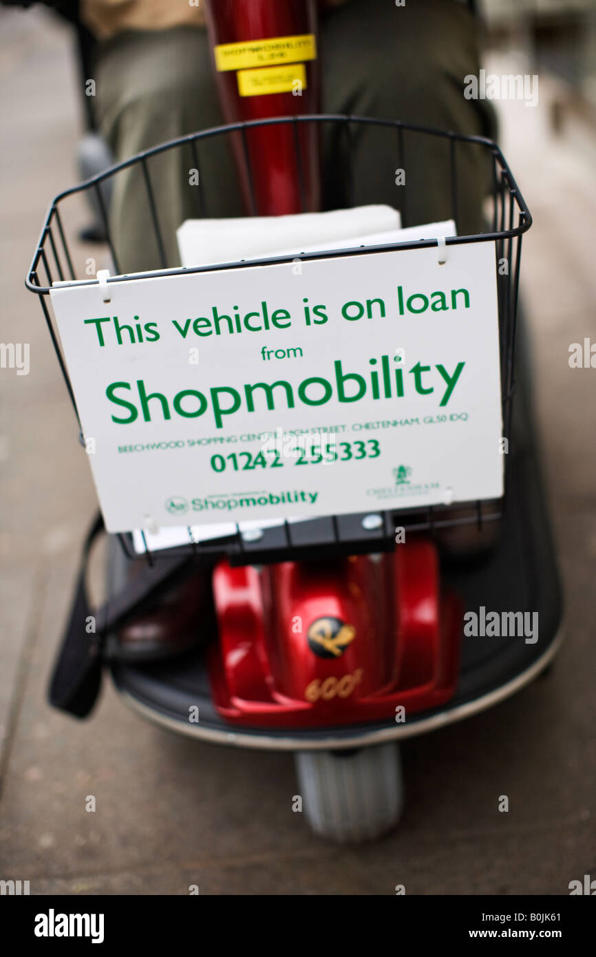 Titolare di pensione o di rendita su uno scooter Shopmobility in Cheltenham town center Foto Stock