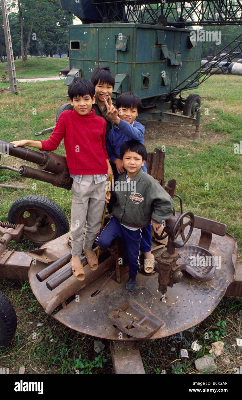 Bambini che giocano su un vecchio anti aerei pistola. Hanoi, Vietnam. Foto Stock