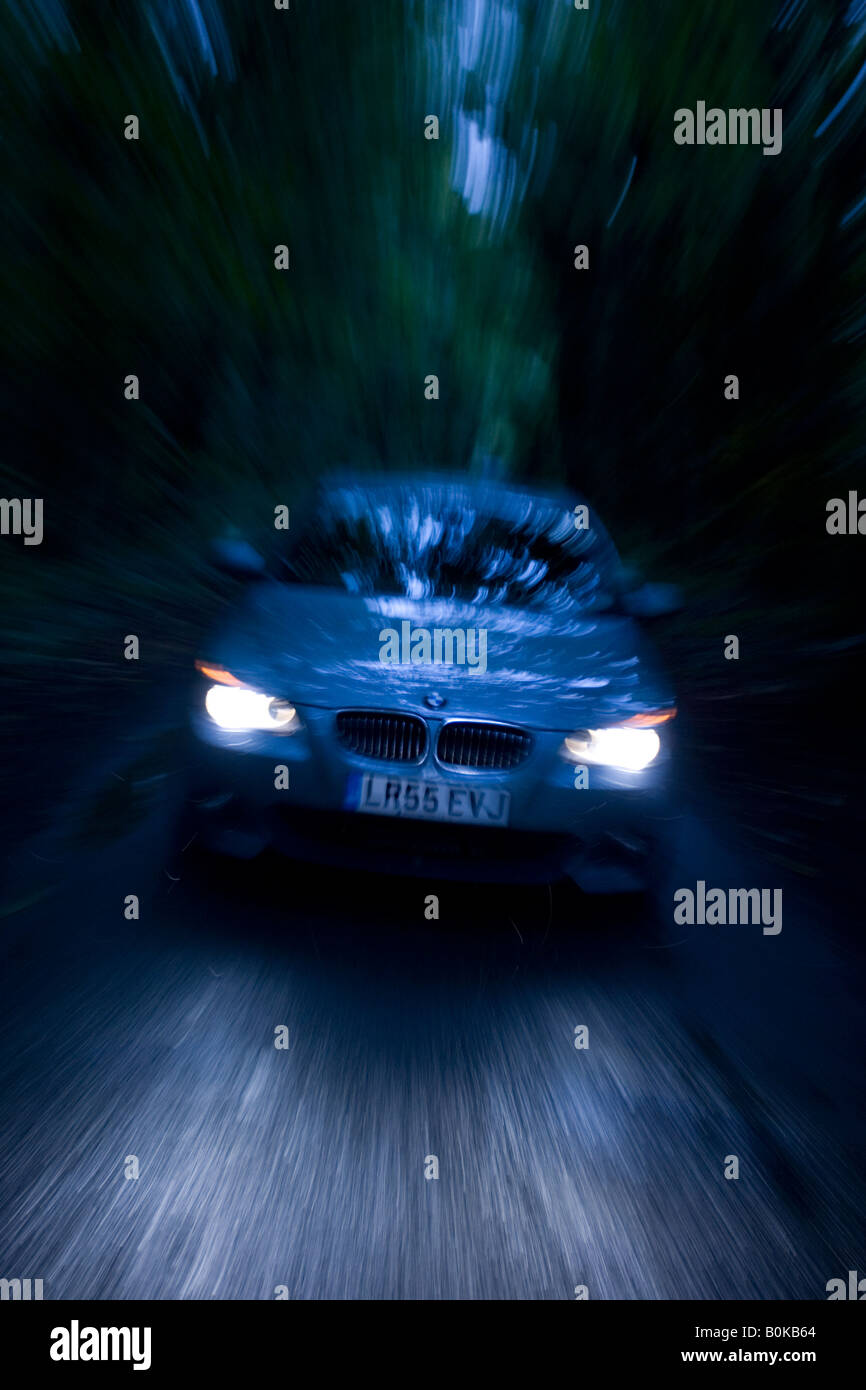 BMW auto sulla strada di campagna nel buio Gloucestershire Regno Unito Foto Stock