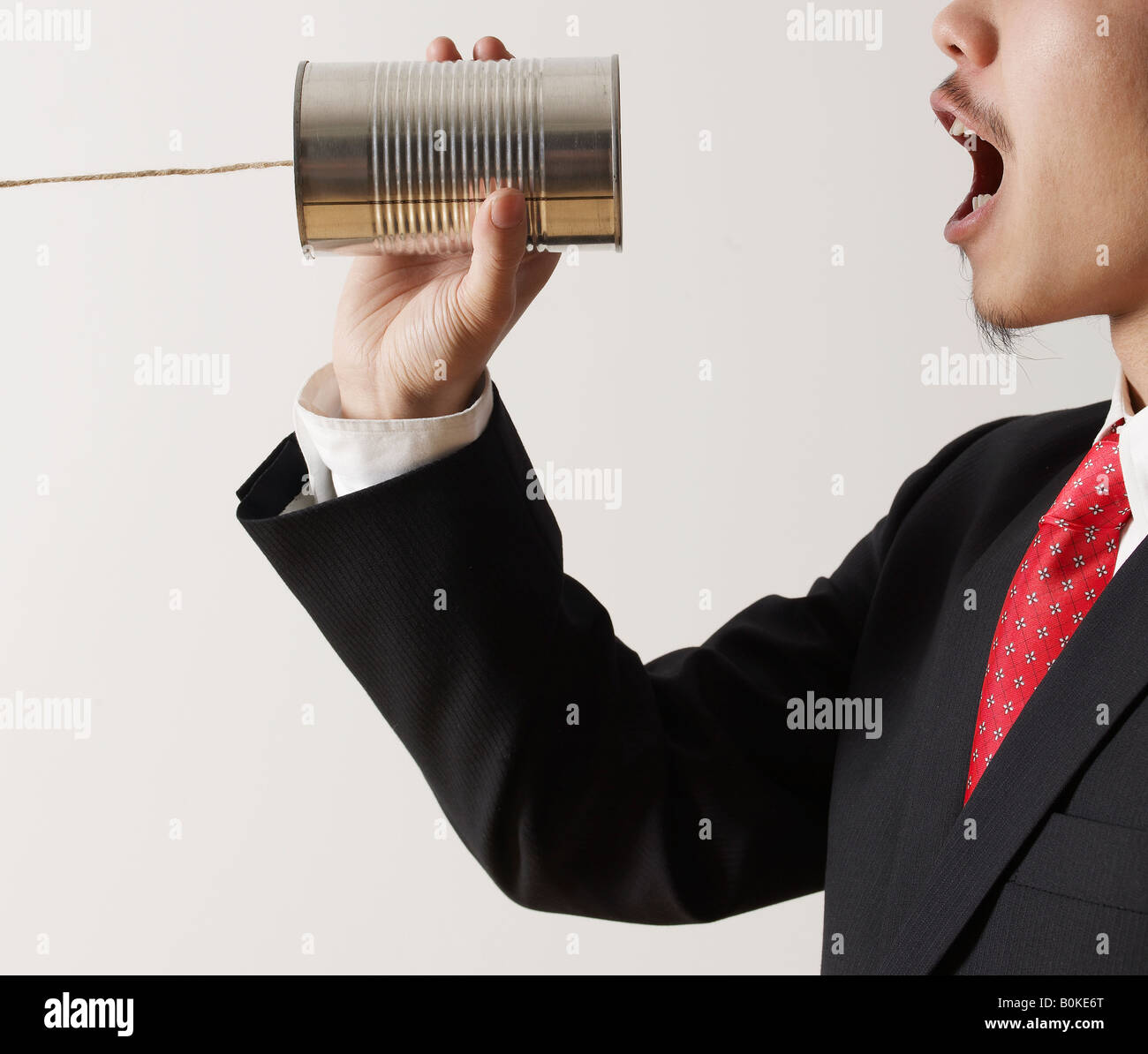 Imprenditore gridando in barattolo di latta telefono Foto Stock