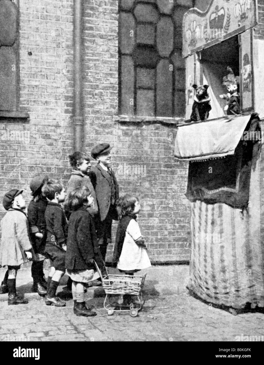 I bambini guardando un punzone e Judy visualizza in una strada di Londra, 1936. Artista: Donald McLeish Foto Stock