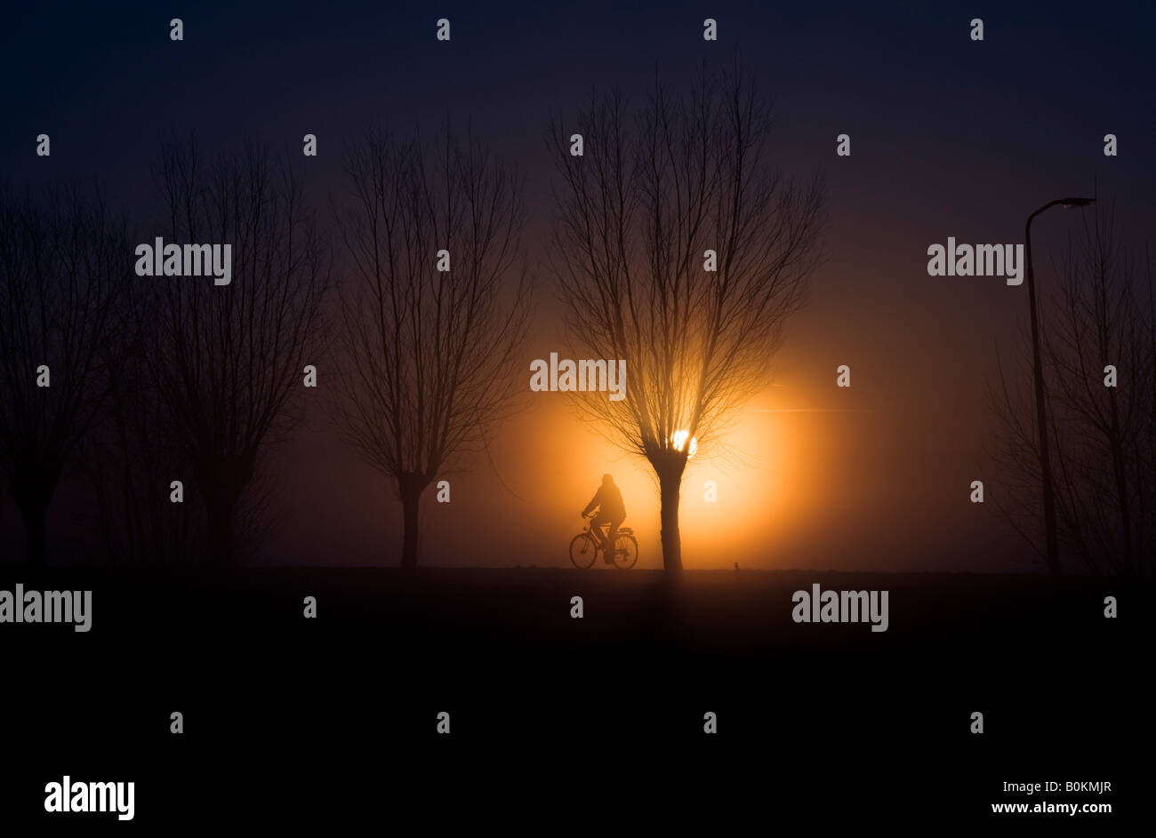 Ciclista durante il sorgere del sole Foto Stock