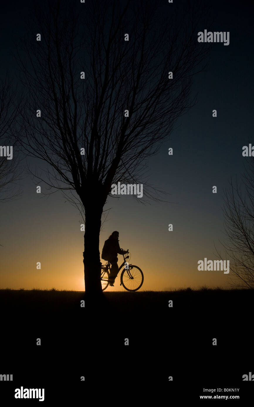 Ciclista durante il sorgere del sole Foto Stock