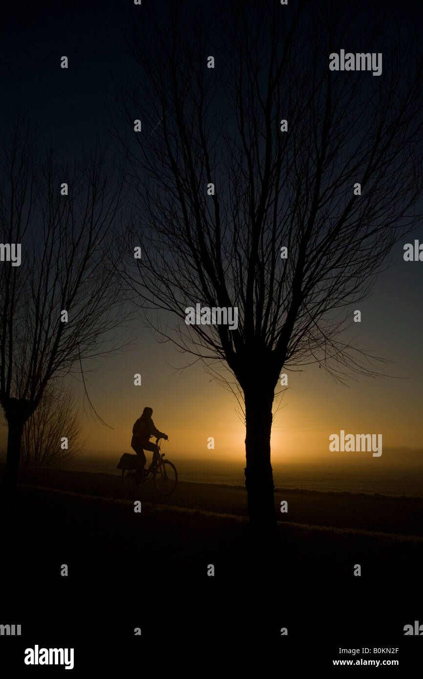 Ciclista durante il sorgere del sole Foto Stock