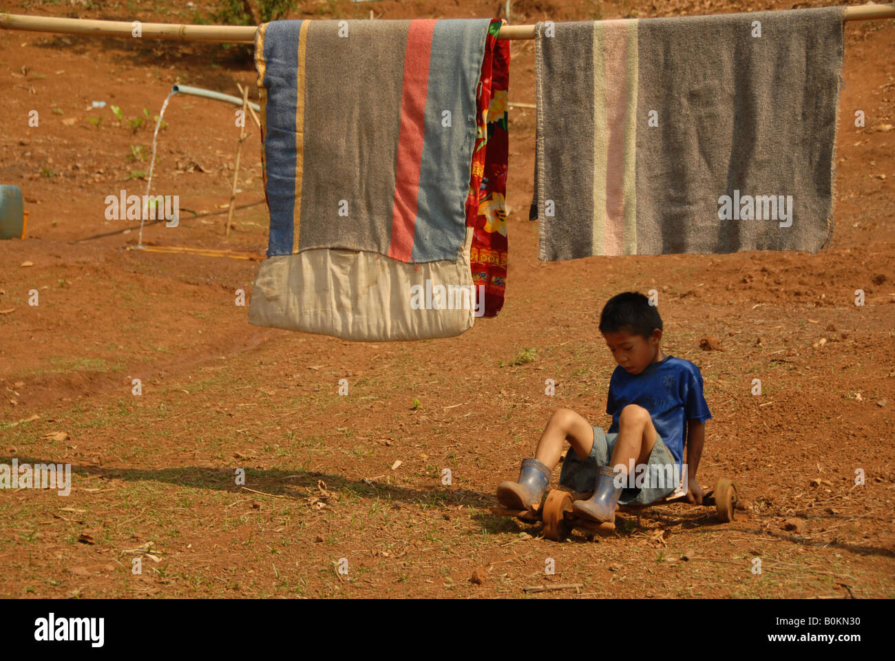 La minoranza thaiyai ragazzo sta giocando con i suoi fatti a mano la ruota del carrello, Mae Hong Son, Thailandia Foto Stock