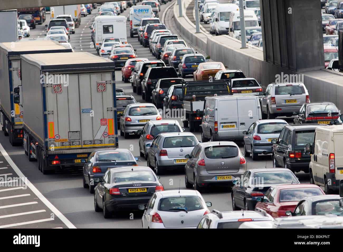 Il traffico di automobili e camion bloccati in una fase di stallo in entrambe le direzioni sulla autostrada M25, London Regno Unito Foto Stock
