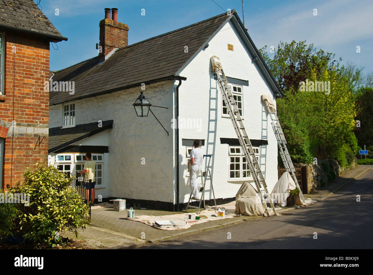 Pittori la decorazione esterna della casa in Lockeridge Wiltshire, Inghilterra UK UE Foto Stock