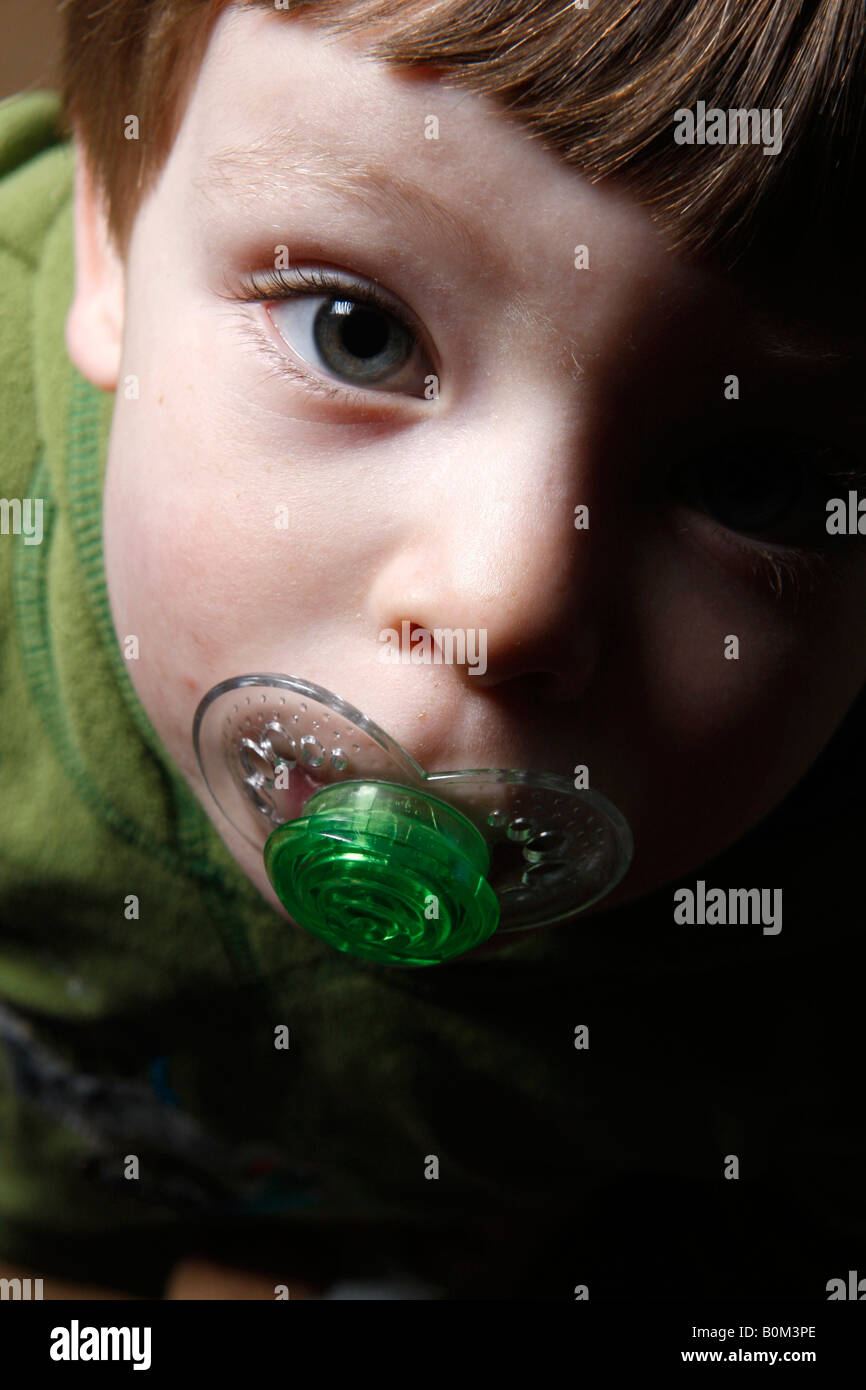 A tre anni ragazzo con un succhiotto ciuccio in bocca Foto Stock
